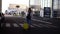 Stylish woman walk with trolley yellow case by empty airport terminal outside road, slender female wearing jeans and