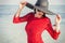 Stylish woman wearing black summer hat and red dress on beach