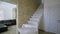Stylish wooden contemporary staircase inside loft house interior. Modern hallway with decorative limestone brick walls and white o