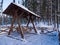 Stylish wooden swing in the Alpine style. Winter evening at the Siberian ski resort Gornaya Salanga