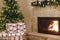 Stylish wrapped christmas gifts, christmas tree with festive lights and cozy burning fireplace. Atmospheric Christmas eve, holiday