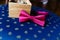 Stylish wristwatch in a wooden box. Pink bow tie. A men\'s set of accessories on an old wooden chair with a soft blue seat. Set of