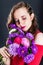 Stylish young beautiful girl who lowered her eyes with purple asters on dark background