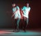 Stylish young boy breakdancer rapper dancing hip-hop in neon light. Long exposure shot