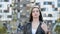 Stylish young brunette girl looking sad at camera portrait on the background of a modern residential area