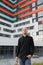 Stylish young businessman freelance architect, standing in front of the modern building.