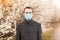 Stylish and young businessman in medical mask walk in spring park