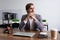 stylish young businessman pensive sitting at the table in the office