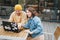 Stylish young couple freelancers working on laptop in the street cafe