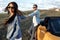 Stylish young couple staying beside a yellow convertible car. Freedom, travel and love concept.