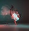 Stylish young guy breakdancer dancing hip-hop in neon light. Dance school poster. Long exposure shot
