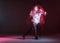 Stylish young guy breakdancer dancing hip-hop in neon light. Dance school poster. Long exposure shot