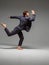 Stylish young guy dancer dancing in suit barefoot  on gray background. Dance school poster