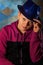 Stylish young man in a blue hat and a lilac sweatshirt. Youth of the future. Studio photography