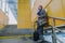 Stylish young man with travel suitcase standing on stairs