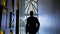 Stylish Young Man Walks Down The Hotel Corridor. He Is Dressed In Suit. View From The Back.