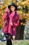 Stylish young woman in fashionable bright sweater and hat posing in the autumn park.