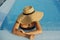 Stylish young woman in hat relaxing in blue pool and enjoying summer holiday. Summer tropical vacation. Girl in sunhat on vacation