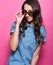 Stylish young woman with long beautiful hair and adjusts her sunglasses