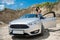 stylish young woman pauses in travel and rests by the roadside near car