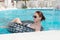 Stylish young woman relaxing in a swimming pool