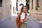 Stylish young woman walking in the medieval city of Ravenna, Italy with Dante Alighieri tomb on the background