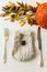 Stylish and zero waste Thanksgiving table setting. Plate with cutlery, linen napkin, anise and autumn leaves, pumpkin, autumnal