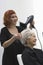 Stylist Blow Drying Senior Woman\'s Hair