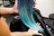 Stylist demonstrates his work with Beautiful girl. Barber haircut dyed hair color blue