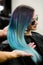 Stylist demonstrates his work with Beautiful girl. Barber haircut dyed hair color blue