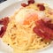 Stylist food, fusion homemade creamy bacon carbonara spaghetti with onsen egg top with parmesan cheese, closed up by focus-on-fore