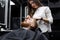 stylist girl shaves beard man in Barbershop.