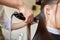 Stylist with iron straightening hair at salon