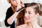 Stylist pinning up a bride\'s hairstyle