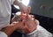 Stylist touching his client`s cheeck with finger, shaving hairs