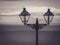 Stylistic street lanterns with sea and clouds in the background