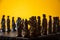 Stylized chess pieces on a board with orange background and selective focus