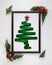 Stylized Christmas tree made from green ribbon with red shiny star and Christmas balls in photo frame on white