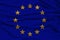 Stylized European Union flag, symbol of united Europe on soft silk with soft folds, close-up