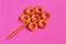 Stylized flower from bagel and bread straws on bright pink background. Symbolic concept â€” world around us through eyes of child