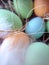 Stylized Happy Easter card,  unfocused closeup  with colorful eggs in nest , feathers and straw.