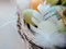 Stylized Happy Easter card,  unfocused closeup  with colorful eggs in nest , feathers and straw.