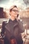 Stylized instagram colorized vintage fashion portrait of a young woman wearing glasses with beauty bokeh and small depth of f