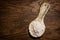 Stylized, old clay rural spoon. Ceramic spoon with flour on a wooden table.