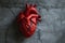 Stylized red paper human heart on gray grunge background. Health and medicine, heart attack, cardiovascular disease