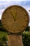 Stylized sculpture of a clock from a thick dry trunk of an old tree.