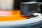 Stylus of headshell on orange vinyl record