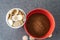 Styrofoam cup full of coins with red bowl of instant coffee