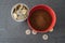 Styrofoam cup full of coins with red bowl of instant coffee