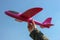 Styrofoam throwing plane-glider in the hand of a woman against the blue sky